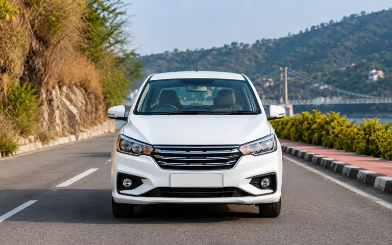 White sedan taxi on scenic road for Dehradun Airport to Rishikesh taxi service with comfortable and safe travel