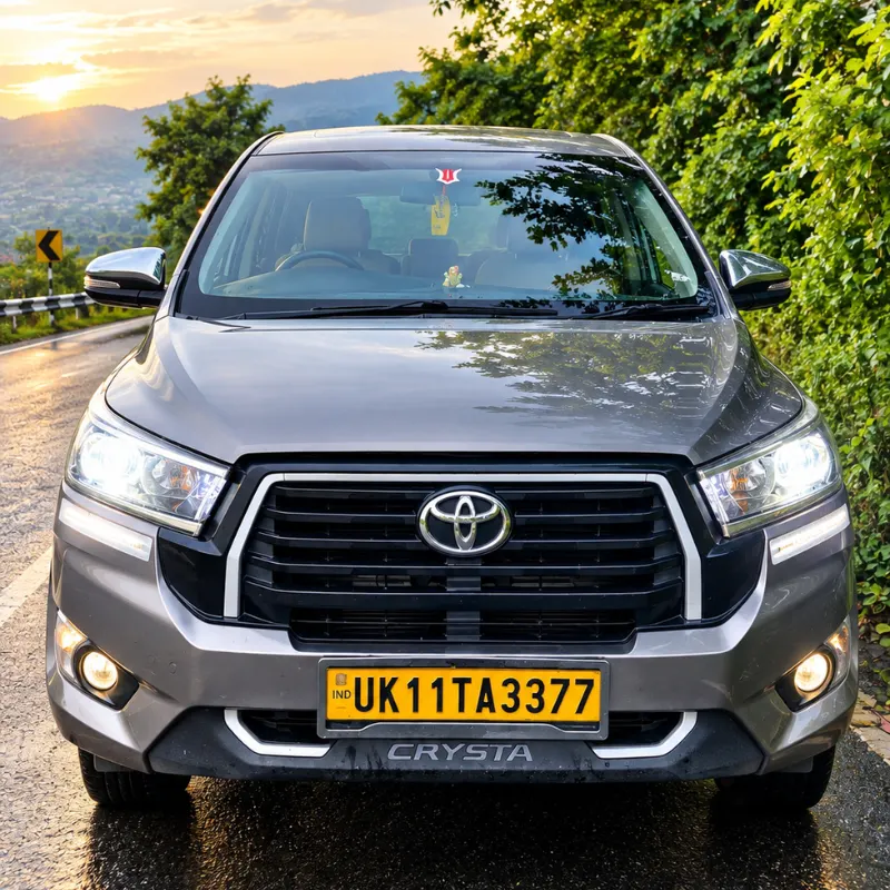 Grey Toyota Innova Crysta taxi parked on mountain road at sunset for Dehradun Airport to Chardham Yatra route